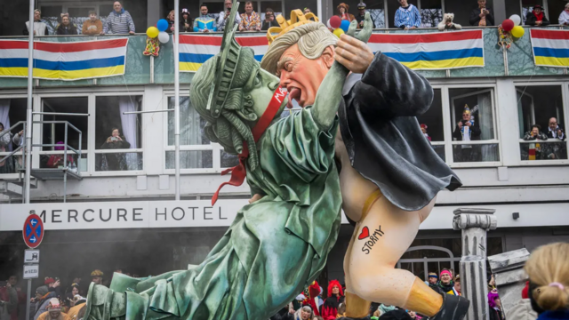 german float with 2 figure on it. a gross depiction of naked trump trying to kill a gagged stature of liberty.