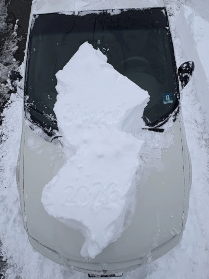 car with NJ shaped snow on hood.